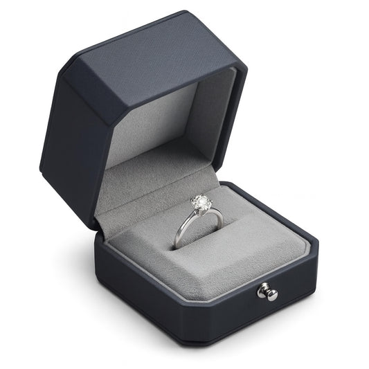 Open black luxury ring box with grey suede interior holding engagement ring