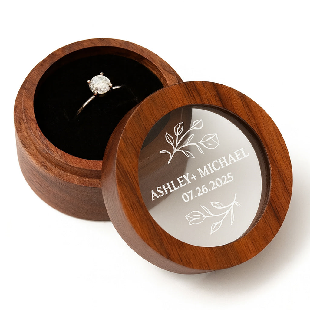 Wooden ring box with engraved names and date on a white background